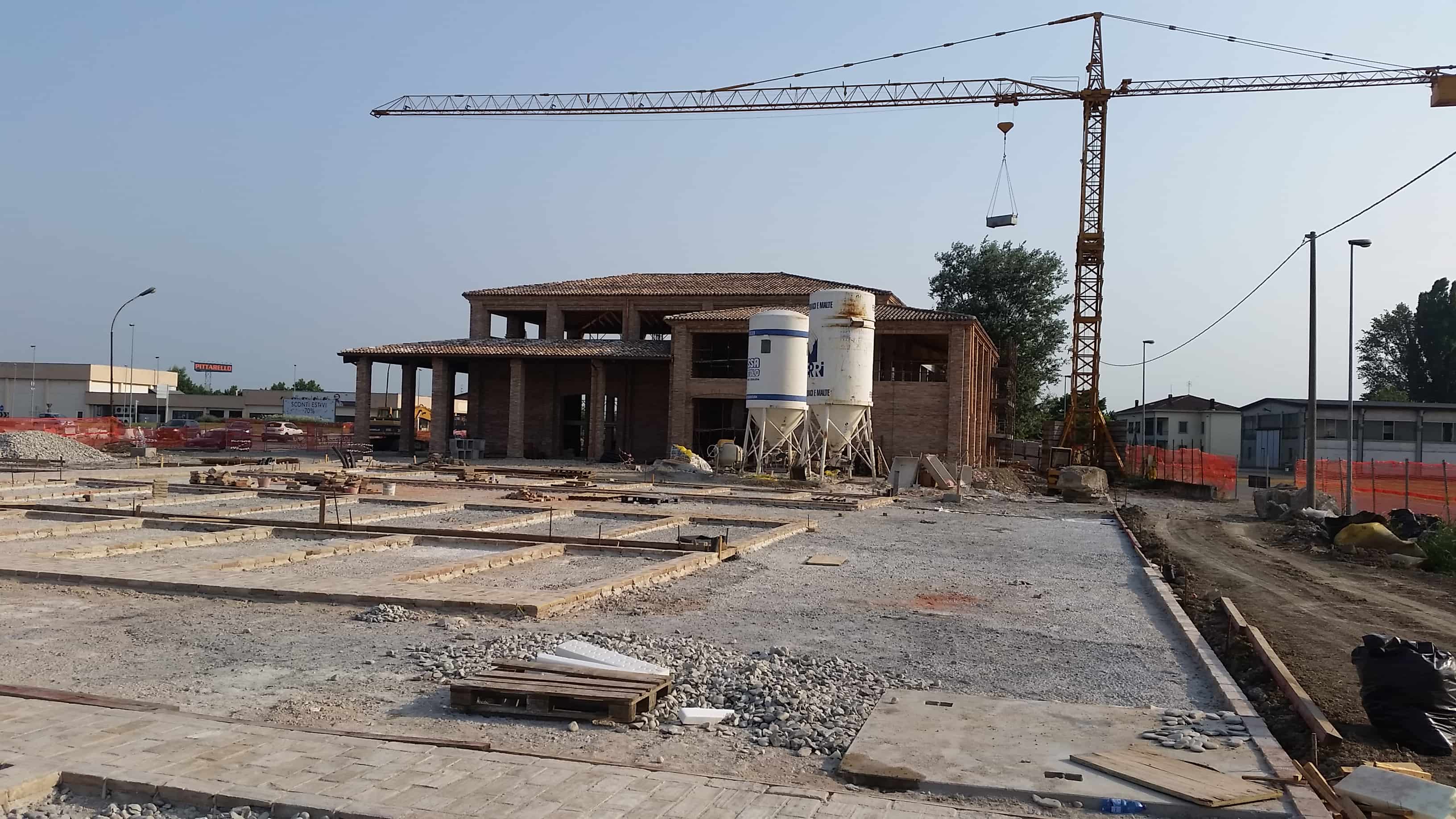 Cantiere del complesso commerciale KM90 in costruzione: fondazioni, struttura grezza e gru