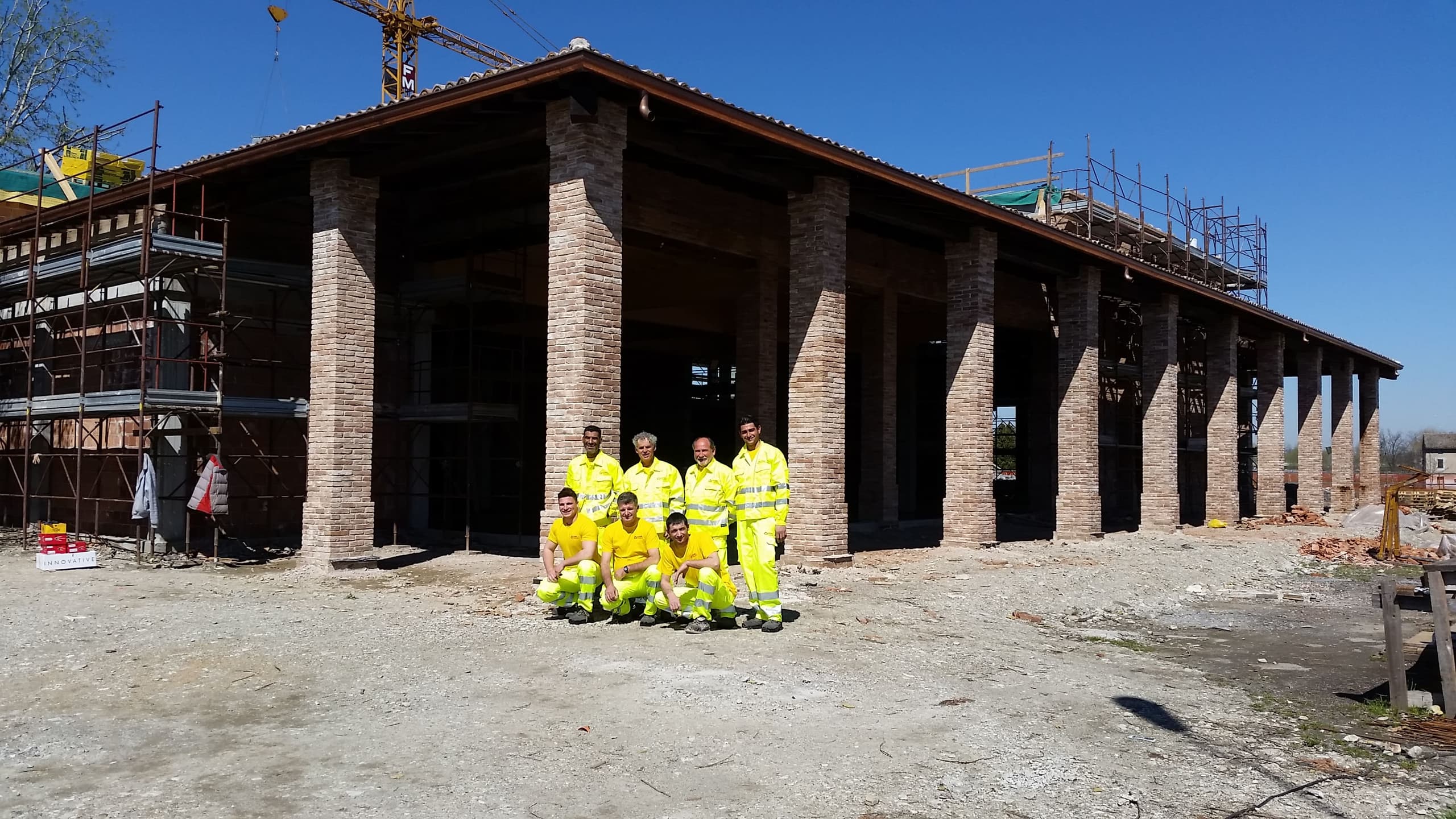 Edificio commerciale in costruzione con squadra New House SRL davanti al portico